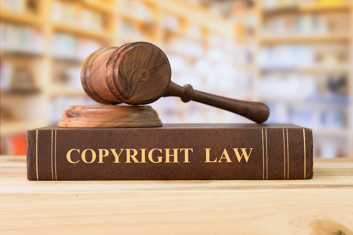 Copyright law book and judge's gavel on desk in library