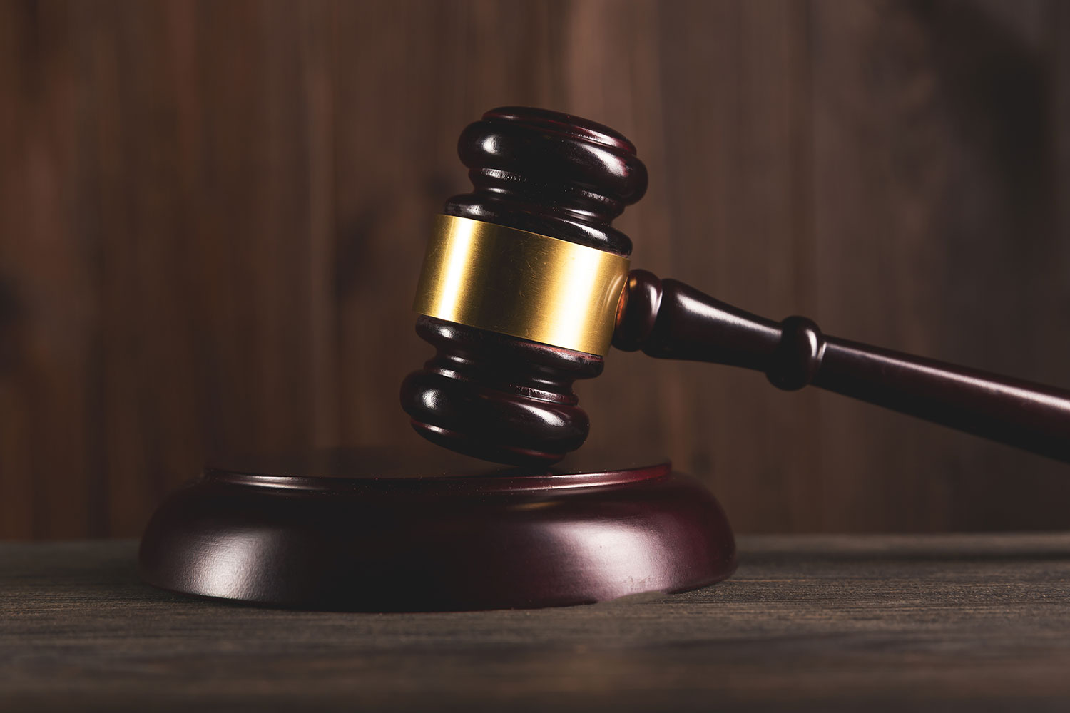 Closeup of a judge's gavel resting on a sound block